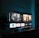 A television screen displaying a user interface with popular streaming service apps including Netflix, Sky, Apple TV, Prime Video, and others. The screen also shows images from movies or shows above the apps. The room is dimly lit with a potted plant visible on the side.