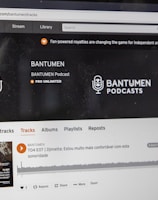 A computer screen displaying a website of an audio streaming service. The website showcases a podcast called BANTUMEN with the description 'Pro Unlimited.' There is a navigation bar with options including Home, Stream, Library, and more. A music wave graphic is visible below, along with a play button, social media interaction options such as re-post, share, and add to playlists. A banner at the top talks about fan-powered royalties, and there is a COVID-19 information widget to the side.